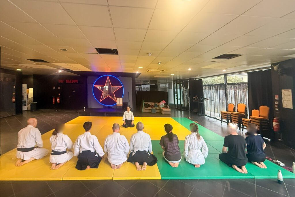 une dizaine de personnes assises pendant la séance de salut en début de cours d'aikido,
